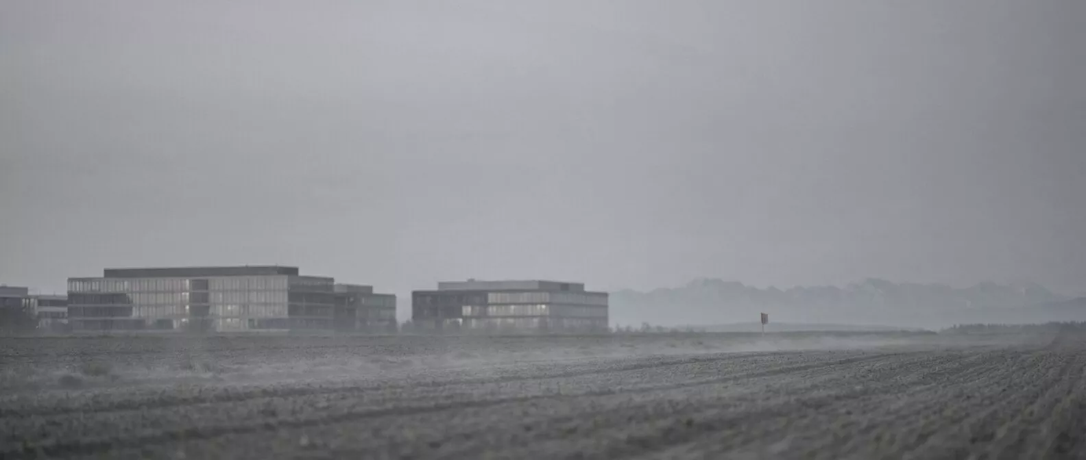 Felder und Bürogebäude östlich von München, am Horizont die Alpen